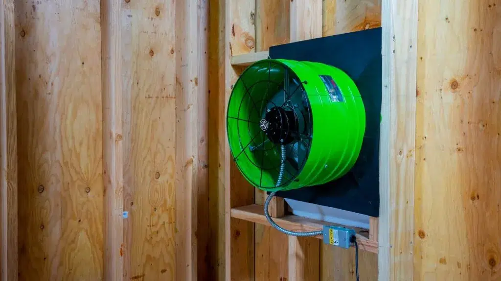 A house with a wooden roof and an attic fan, illustrating a harmonious design for comfort & airflow.