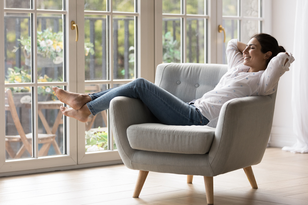 Is a heat pump right for you - Pretty Indian woman chilling on a comfortable armchair